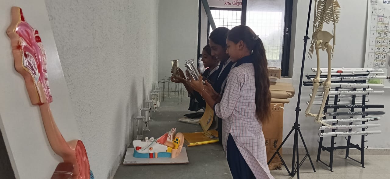 Students exploring models and equipment in a school science and mathematics lab