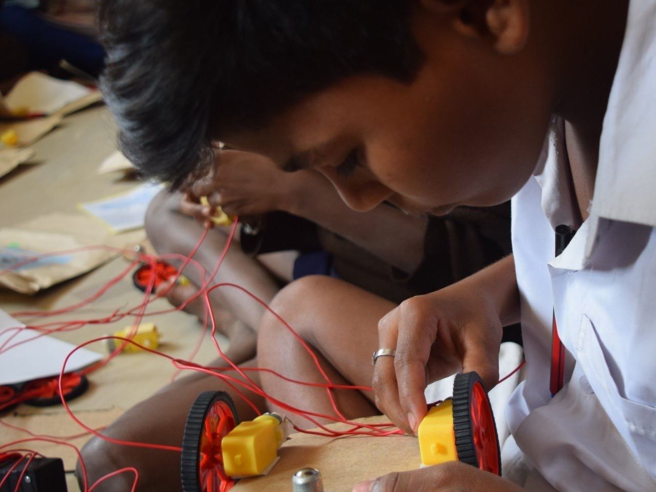 A student building a wired vehicle during a hands-on STEM activity